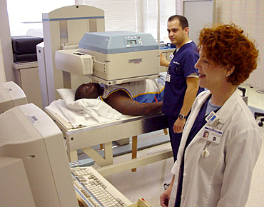 Photograph of technicians conducting a MUGA scan. Photograph of technicians conducting a MUGA scan.